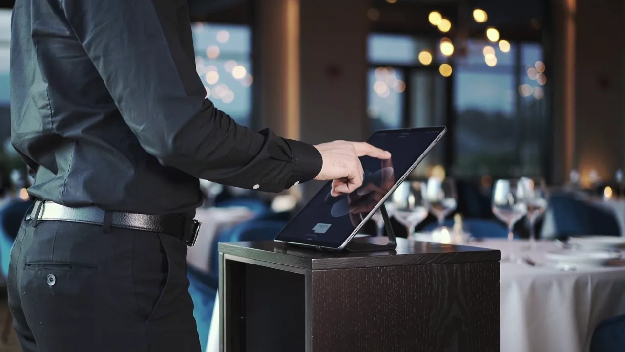 Illustrative restaurant host at a tablet, coordinating the dining room